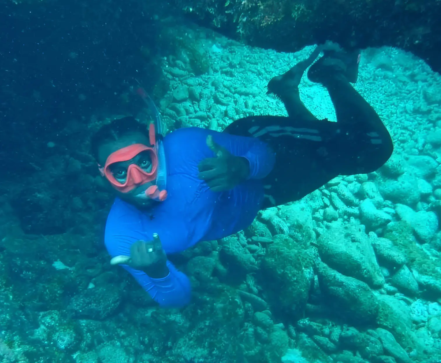 A diver over a reef in clear blue water