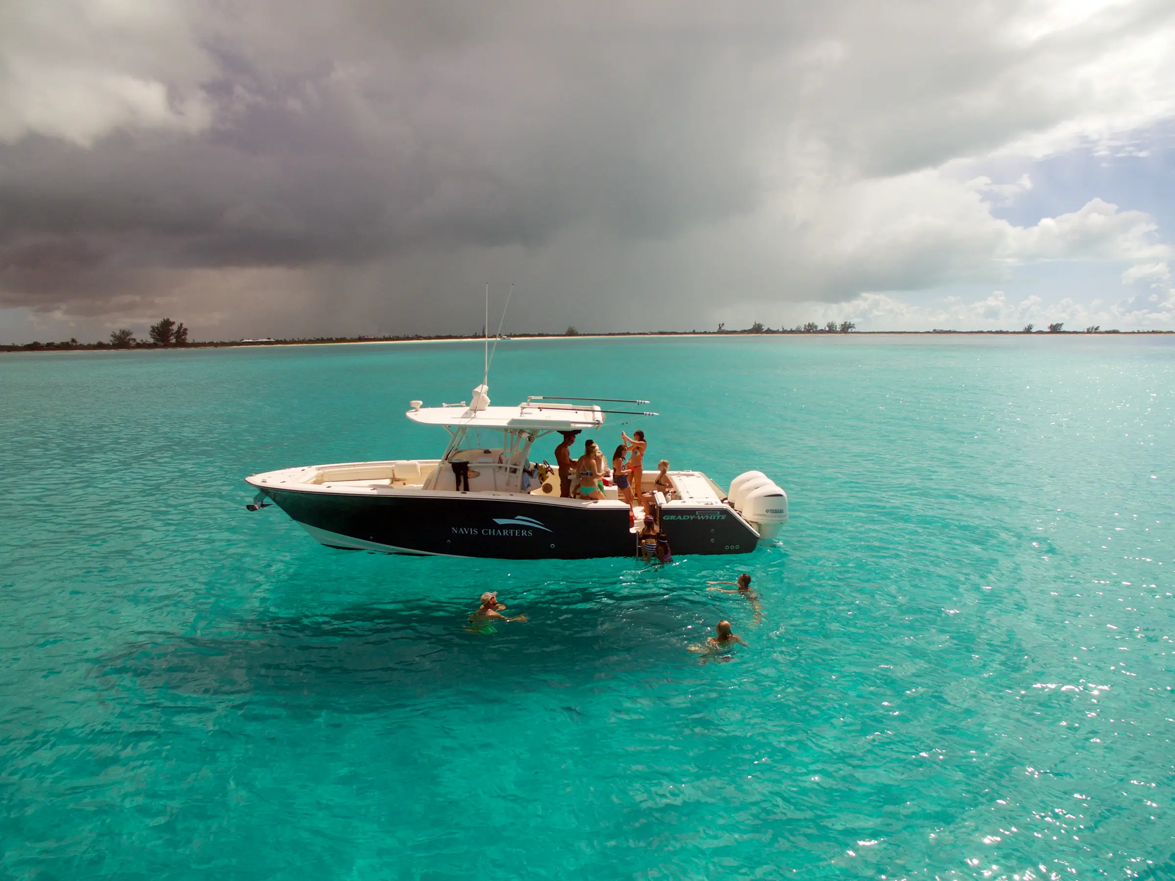 Sweet T anchored over shallow turquoise water under a stormy sky