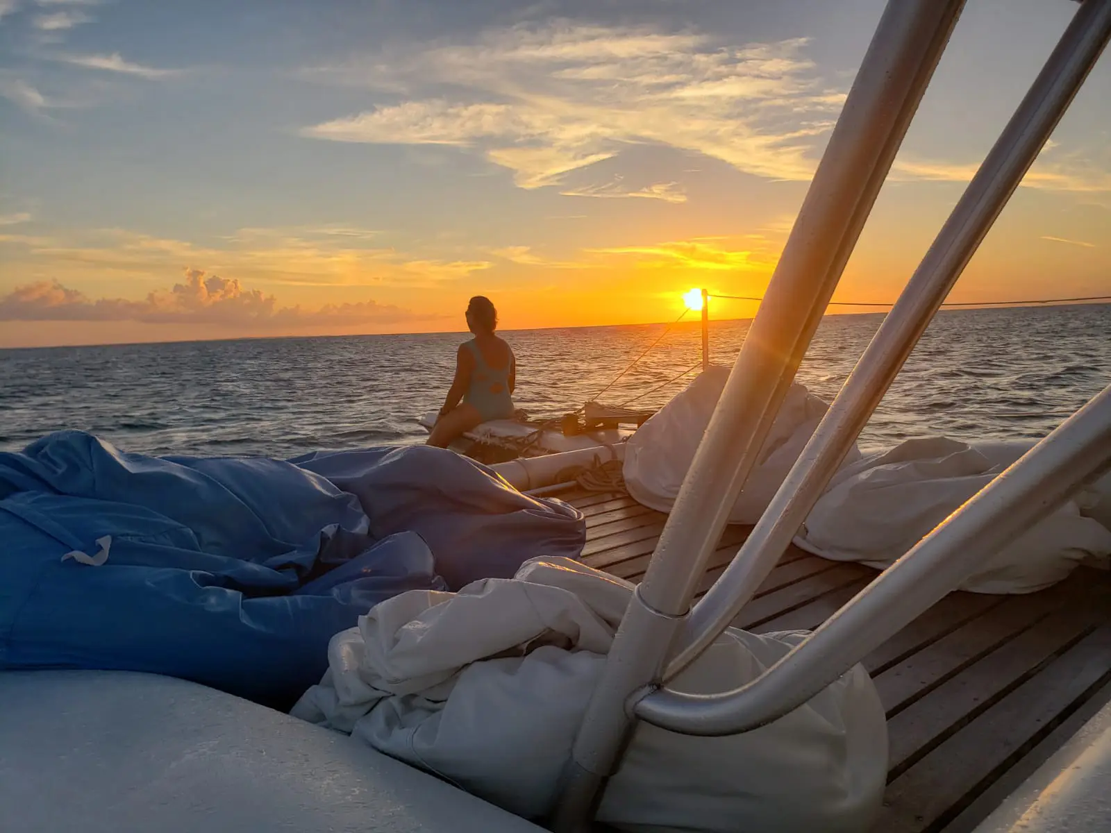 Sunset over the water from the deck of a catamaran